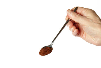 Men's hand holding spoon with coffee powder isolated white background. Coffee preparation, closeup