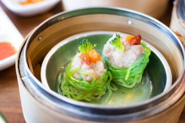 Shrimp dumplings wrapped in jade noodles in a dim sum steamer, a filling and delicious breakfast.