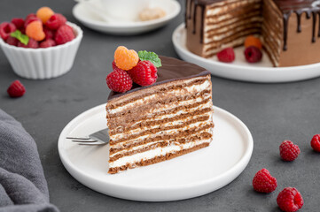 Layered honey chocolate cake with glaze and fresh raspberries on top. Delicious chocolate cake.