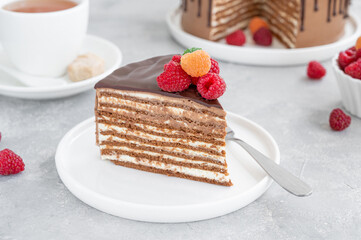 Layered honey chocolate cake with glaze and fresh raspberries on top. Delicious chocolate cake.