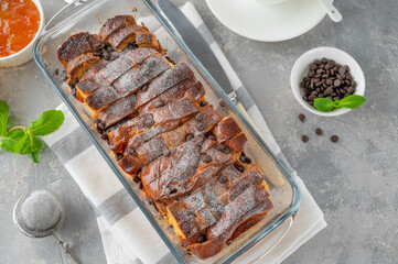 Homemade bread pudding with chocolate chips on a gray concrete background. Selective focus, copy space.