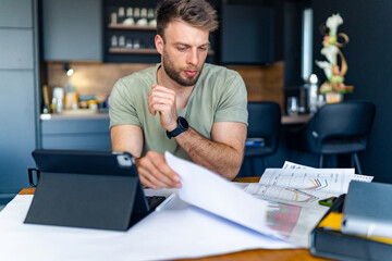 A man checks financial statements, charts for an investment fund in his company.
