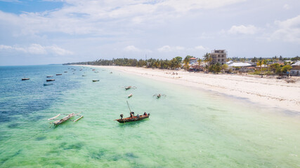 From above, the stunning landscape of Zanzibar's tropical coast comes into focus, with fishing...