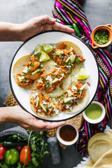 Mexican woman hands holding tacos al pastor and eating mexican food in Mexico Latin America