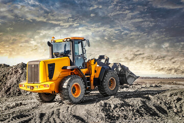 Powerful wheel loader or bulldozer working on a quarry or construction site. Earthworks in...