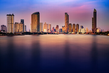 Bangkok city skyline at sunset with River view and sky scraper and ferris wheel romantic atmosphere in Thailand 