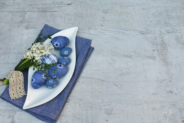 Schale mit blauen Ostereiern auf einem schäbigen hellen Hintergrund mit Platz für Text.