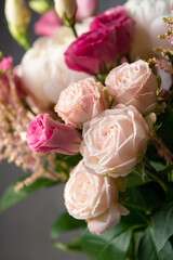 Bushy light pink roses with blurred flowers on a gray background.