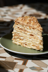 A piece of Napoleon cake on plate, close-up.