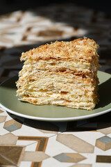 A piece of Napoleon cake on plate, close-up.