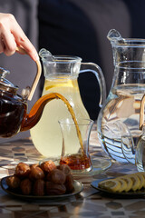 Ramadan food table with dates, glass of water, tea pot