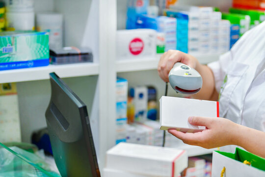 Pharmacist scanning barcode of medicine drug in a pharmacy drugstore.