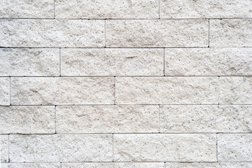 Cream and white brick wall texture background. Brickwork or stonework flooring interior rock old pattern clean concrete grid uneven bricks design stack.