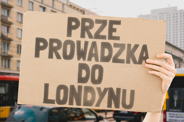The phrase " Moving to London " on a carton banner in men's hand. Industry. Office. Hire. Labor. Hiring. Recruitment. Employ. Recruit. Contract. Transfer. Rules. Operation. Process
