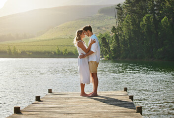 Couple, lake and engagement announcement of young people in love in nature. Happy, relax and hug of...