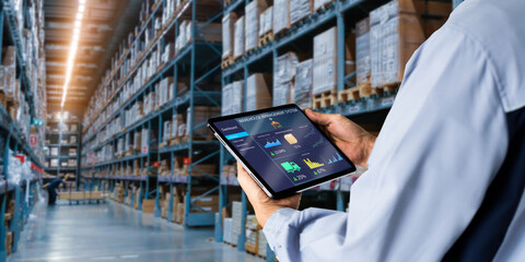 Smart Warehouse,Inventory management system concept.Manager using digital tablet,showing warehouse software management dashboard on blurred warehouse as background - obrazy, fototapety, plakaty