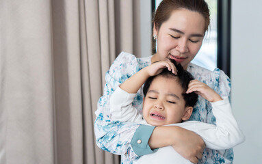 Angry asian kid .Little asian boy angry and crying while his mother holding him.