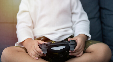 Cropped image of  boy with joystick playing video game at home. Selective focus