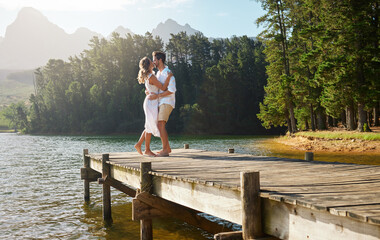 Love, couple and dance at lake pier, smile and bonding together outdoors on vacation. Dancing date,...