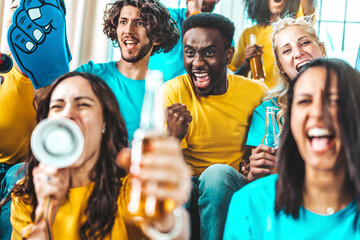 Multiracial joyful sport fans sitting on couch watching game on TV - Group of people celebrating...