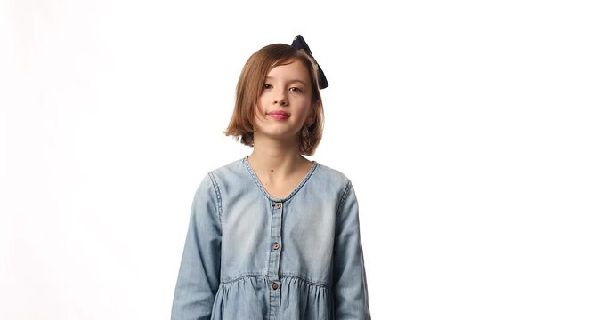 Teen girl child wearing jeans dress put hand on face facepalm in studio on white background, epic fail, amazed with stupid situation