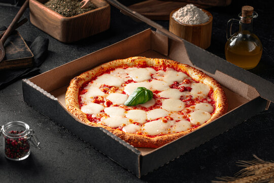 Portion of take away backed margherita pizza with cheese