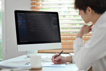 Obraz na płótnie Canvas Coding programmer, software engineer sitting at desk, working in software development office
