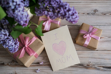 A bouquet of lilacs and a card with the text I love mom. Mother's day concept