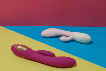 Two dildo vibrators for satisfaction on colored background. Sex toy for adult. Sex shop concept