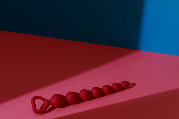 Anal plug or dildo on pink background with shadows. Sex shop concept. Sex toys for anal play