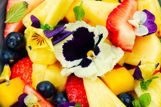 Fresh fruit salad with flowers, vegan food