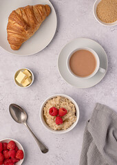 Food photography of oatmeal, oat, porridge, breakfast, croissant, tea, milk, raspberries, butter
