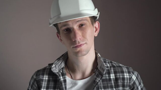 A young man puts on a construction helmet. close-up. isolated.