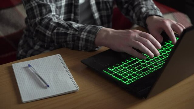 a man works at a laptop. notebook on the table.