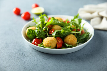 Healthy arugula salad with fish croquettes