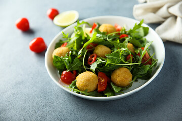 Healthy arugula salad with fish croquettes