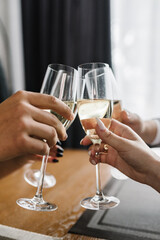 Cheers. People celebrate and raise glasses of sparkling wine for toast. Group of man and woman cheering with champagne. Friends are drinking at a party. Сloseup.