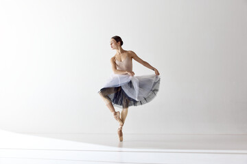 One adotable ballerina holding tutu and dancing over white background