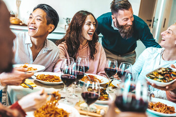 Happy group of friends having dinner party at home - Cheerful young people having lunch break together - Life style concept with guys and girls celebrating thanksgiving - Food and beverage lifestyle