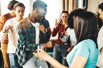 Diverse group of friends having home party together - Funny young people having fun dancing and...