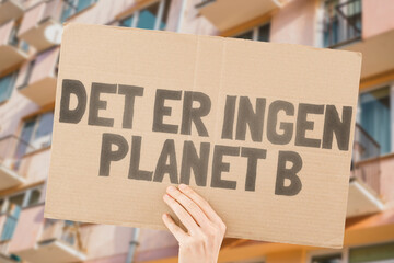 The phrase " There is no planet B " is drawn on a carton banner in men's hands. Climate change. Protest. Global warming. Zone. Disaster. Tension. Poison. Toxin. Damage. Impact. Air
