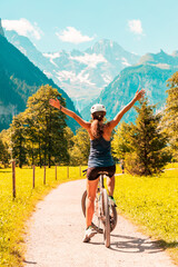 Woman by bike at Lauterbrunnen valley with gorgeous waterfall and Swiss Alps, Bern-Switzerland