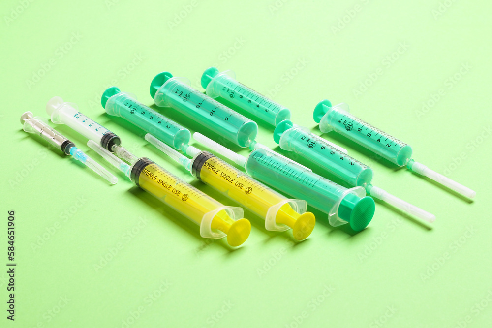 Wall mural top view of medical syringes with needles at green background with copy space. injection treatment c