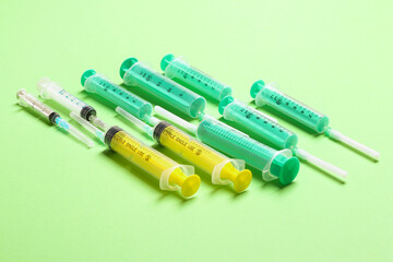 Top view of medical syringes with needles at green background with copy space. Injection treatment concept