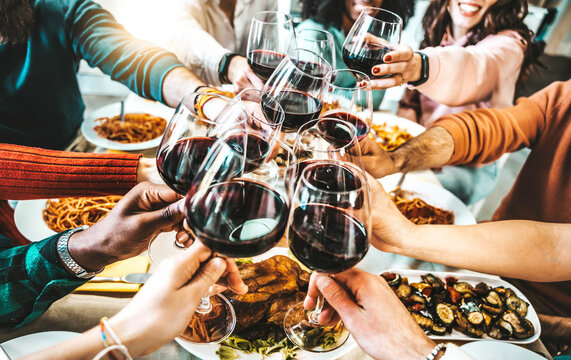 Happy friends toasting red wine glasses at dinner party - Group of people having lunch break at bar restaurant - Life style concept with guys and girls hanging out together - Food and beverage