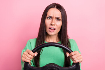 Photo of unhappy young latin car driver lady hold steering wheel green jumper dissatisfied car traffic long range isolated on pink color background - obrazy, fototapety, plakaty