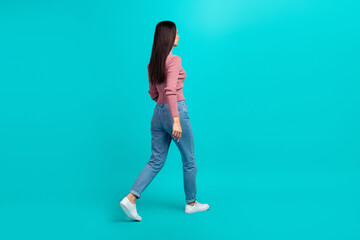 Full length profile portrait of walking young person look empty space isolated on turquoise color...