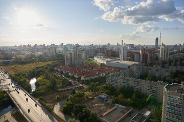 Fototapeta na wymiar Apartment buildings in the background. Dense buildings of the city visible from above. Blue sky with clouds. RUSSIA - August 14, 2022, high-rise buildings from a height. High quality photo