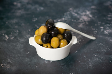 Black and green olives in wooden bowls.