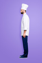 Full size fullbody snap, profile portrait of attractive, harsh, virile chef cook with stubble in beret, isolated over grey background